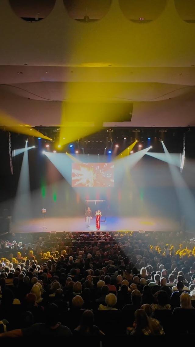 Jen Kramer performing her live show before a packed theater audience